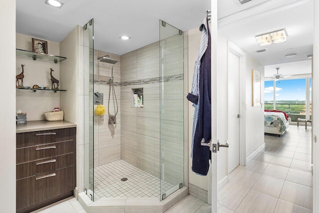 bathroom with ceiling fan, a shower with door, and tile patterned flooring