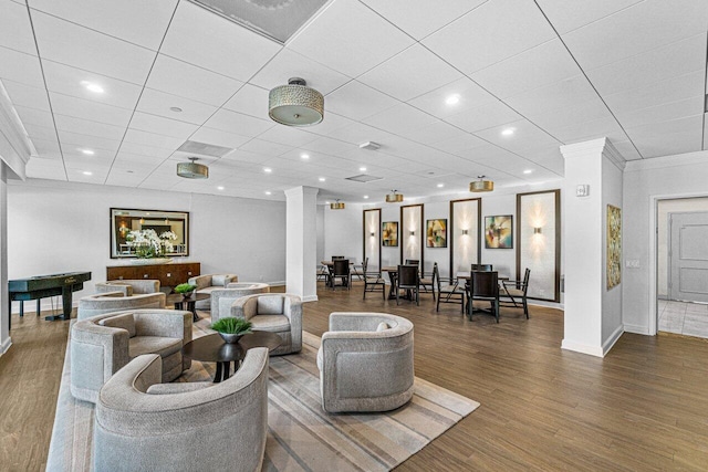 living room featuring crown molding, a paneled ceiling, and wood-type flooring