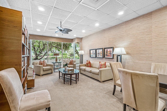 living room featuring light carpet, a paneled ceiling, and ceiling fan