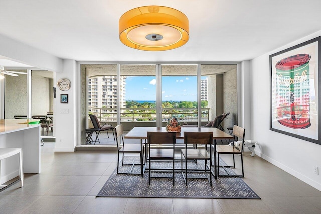 dining area featuring a wall of windows and ceiling fan