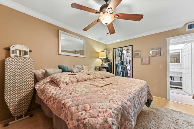 bedroom featuring ceiling fan, light hardwood / wood-style floors, crown molding, and a closet