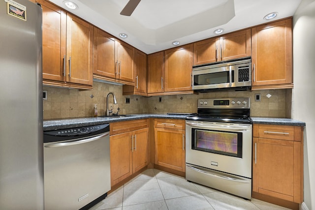 kitchen featuring backsplash, light tile patterned flooring, sink, and appliances with stainless steel finishes