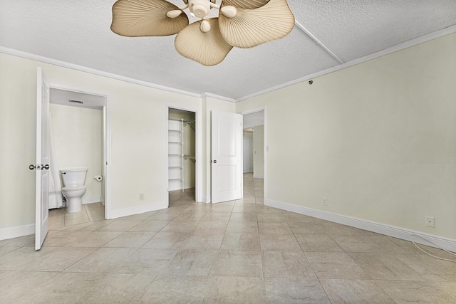 unfurnished bedroom featuring ceiling fan, light tile patterned flooring, a textured ceiling, and ensuite bath