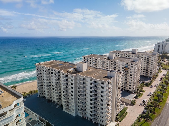 drone / aerial view with a water view and a beach view