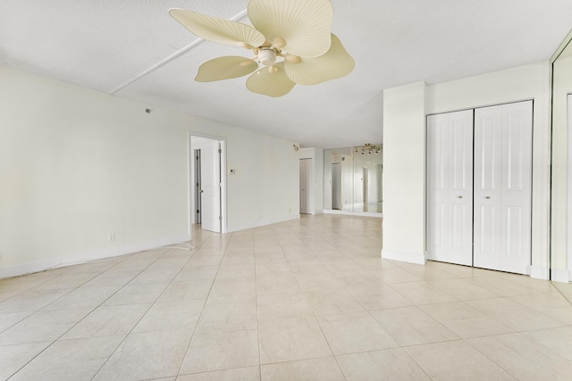 tiled empty room with a textured ceiling and ceiling fan