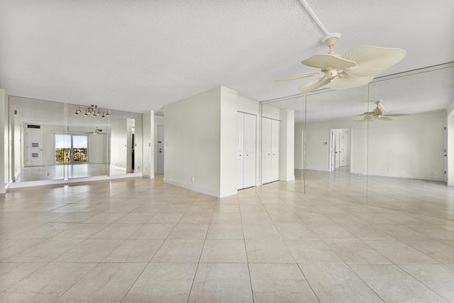 empty room with light tile patterned floors, a textured ceiling, and ceiling fan