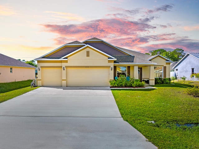 ranch-style house with a garage and a yard