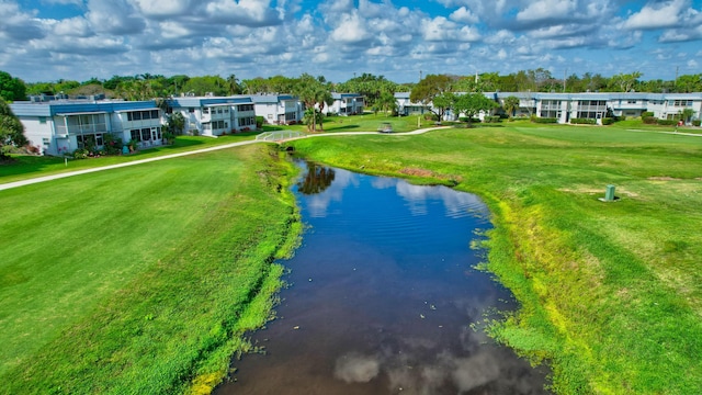 view of property's community with a water view and a lawn