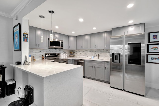 kitchen with hanging light fixtures, tasteful backsplash, kitchen peninsula, appliances with stainless steel finishes, and ornamental molding