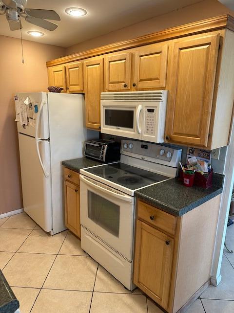 kitchen featuring ceiling fan, light tile patterned flooring, and white appliances