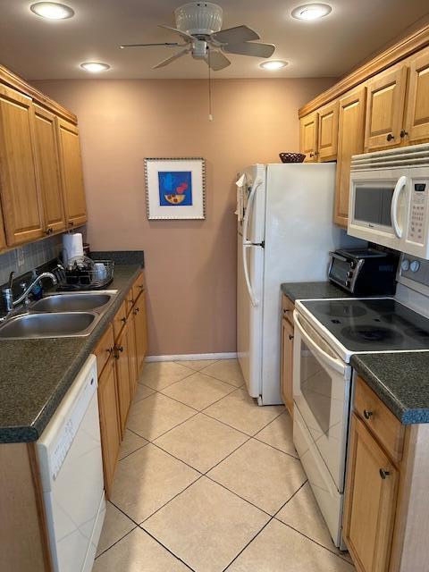 kitchen featuring ceiling fan, sink, light tile patterned floors, and white appliances