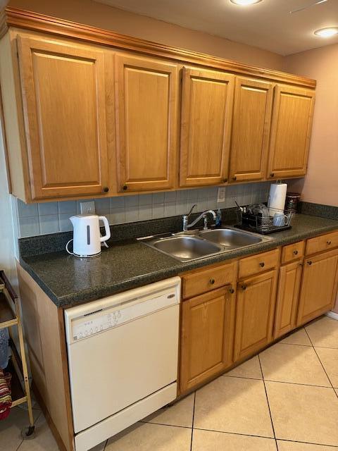 kitchen with dishwasher, light tile patterned floors, backsplash, and sink