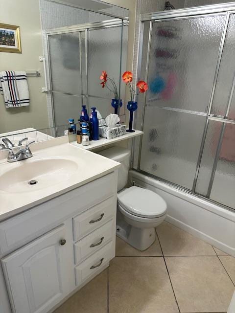 full bathroom featuring tile patterned flooring, vanity, enclosed tub / shower combo, and toilet