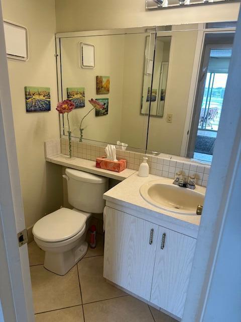 bathroom with backsplash, vanity, a wall mounted AC, tile patterned flooring, and toilet