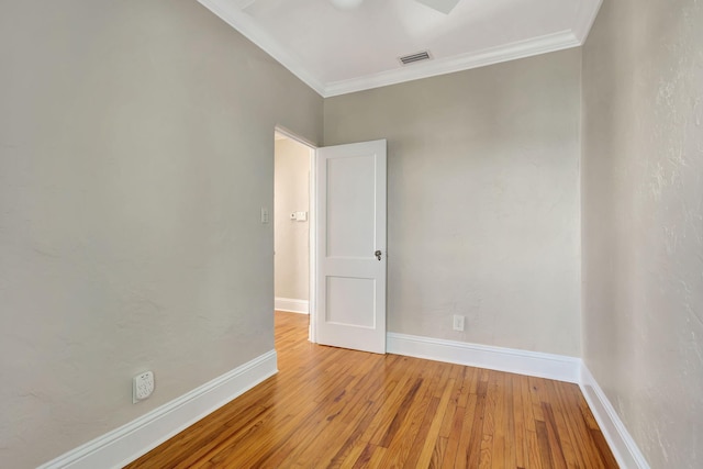 empty room featuring light hardwood / wood-style floors and crown molding