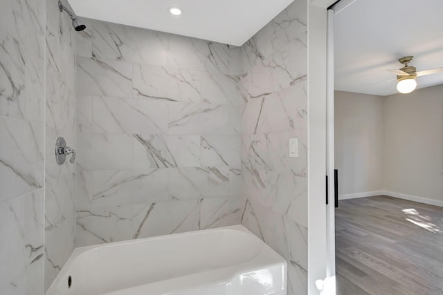 bathroom featuring ceiling fan, wood-type flooring, and tiled shower / bath combo