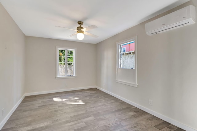 empty room with ceiling fan, light hardwood / wood-style flooring, and a wall mounted AC