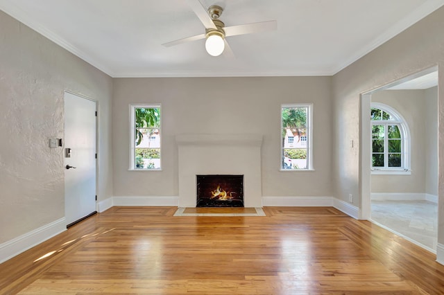 unfurnished living room with ceiling fan, light wood-type flooring, and crown molding