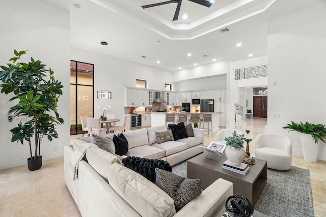 living room featuring beverage cooler, visible vents, a towering ceiling, a tray ceiling, and recessed lighting