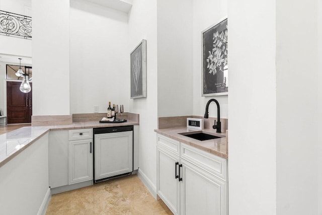 kitchen featuring light stone counters and a sink