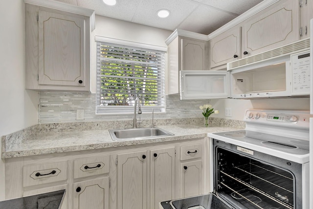 kitchen with white appliances, backsplash, a drop ceiling, and sink