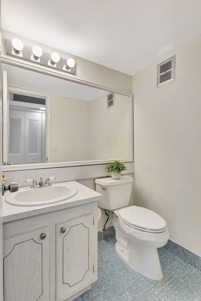 bathroom featuring tile patterned floors, vanity, and toilet