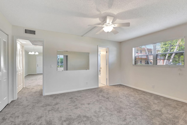 empty room with light carpet, a textured ceiling, and ceiling fan