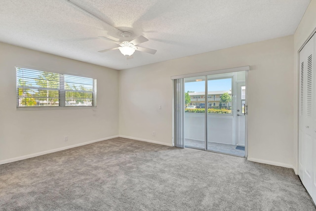 unfurnished room featuring carpet flooring, a healthy amount of sunlight, and a textured ceiling