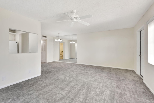 carpeted spare room with ceiling fan with notable chandelier and a textured ceiling