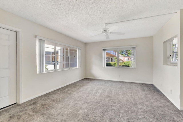 carpeted spare room featuring a textured ceiling, plenty of natural light, and ceiling fan