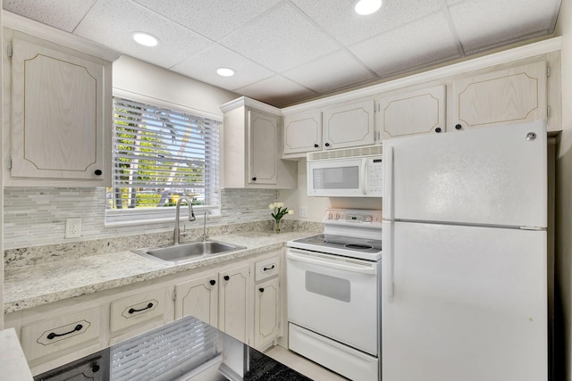 kitchen featuring white appliances, tasteful backsplash, a paneled ceiling, and sink