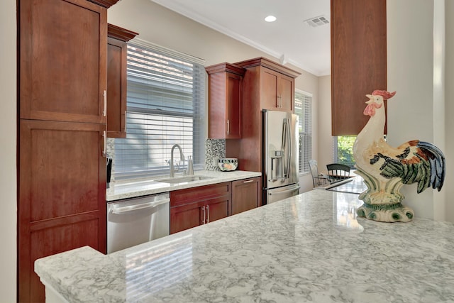 kitchen featuring appliances with stainless steel finishes, a wealth of natural light, ornamental molding, and sink