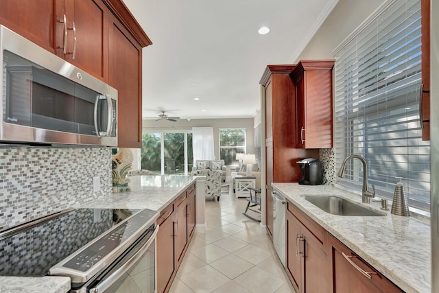 kitchen with light stone countertops, backsplash, and stainless steel appliances