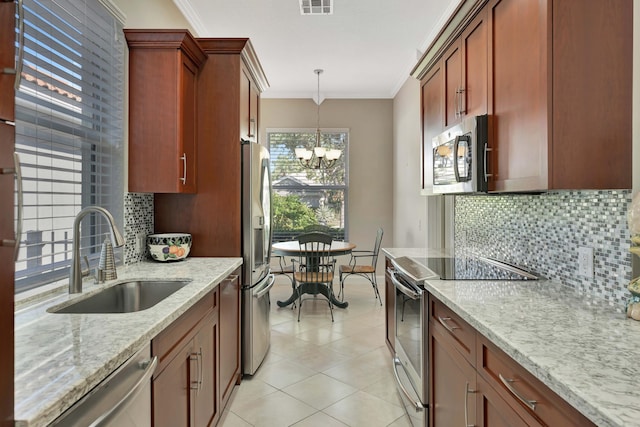 kitchen featuring hanging light fixtures, sink, ornamental molding, and appliances with stainless steel finishes