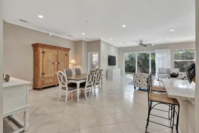 tiled dining area featuring ceiling fan and crown molding