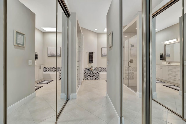 corridor with light tile patterned floors and a skylight