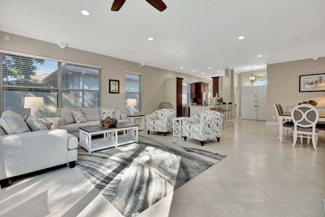 tiled living room with ceiling fan and ornamental molding