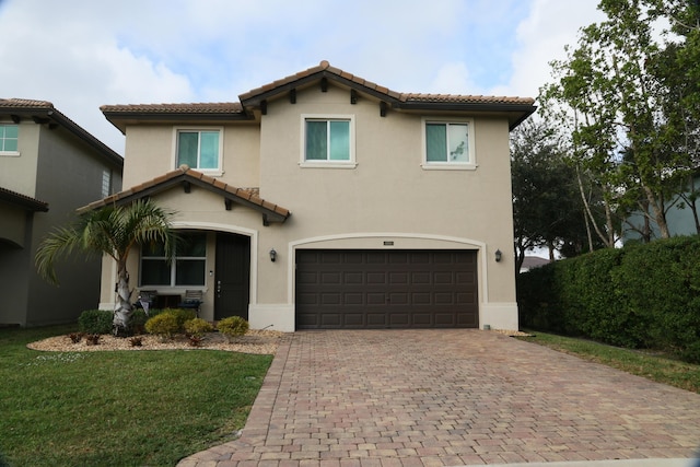 mediterranean / spanish house with a garage and a front lawn