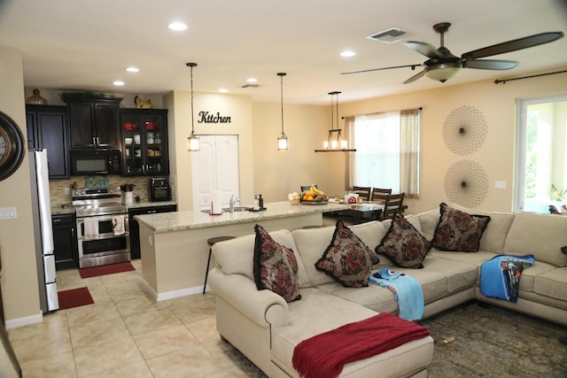 living room featuring ceiling fan, light tile patterned floors, and sink