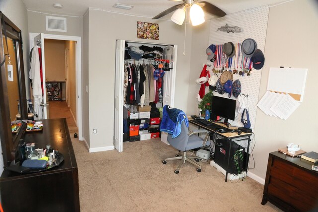 carpeted office space featuring ceiling fan