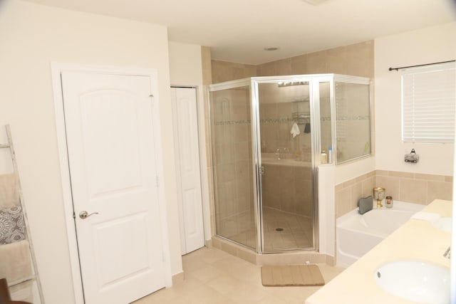 bathroom featuring tile patterned flooring, separate shower and tub, and sink