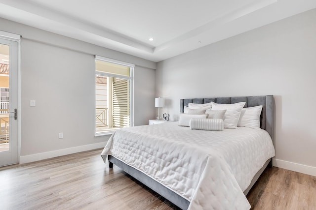 bedroom with access to outside and hardwood / wood-style floors