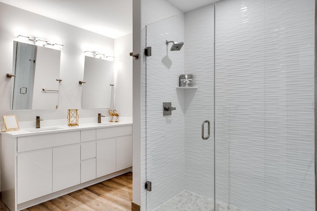 bathroom featuring hardwood / wood-style flooring, vanity, and a shower with shower door