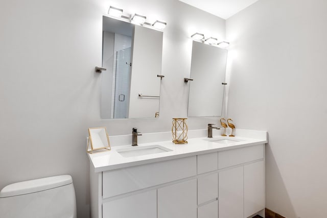 bathroom with a shower with door, vanity, and toilet