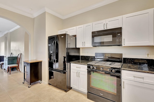 kitchen with dark stone counters, light tile patterned flooring, white cabinets, and black appliances