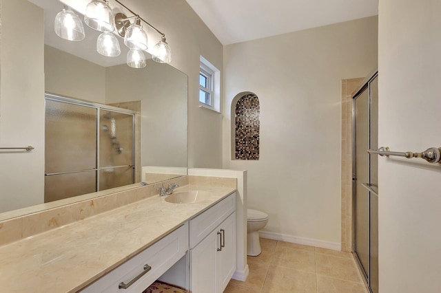 bathroom with tile patterned flooring, vanity, toilet, and a shower with shower door