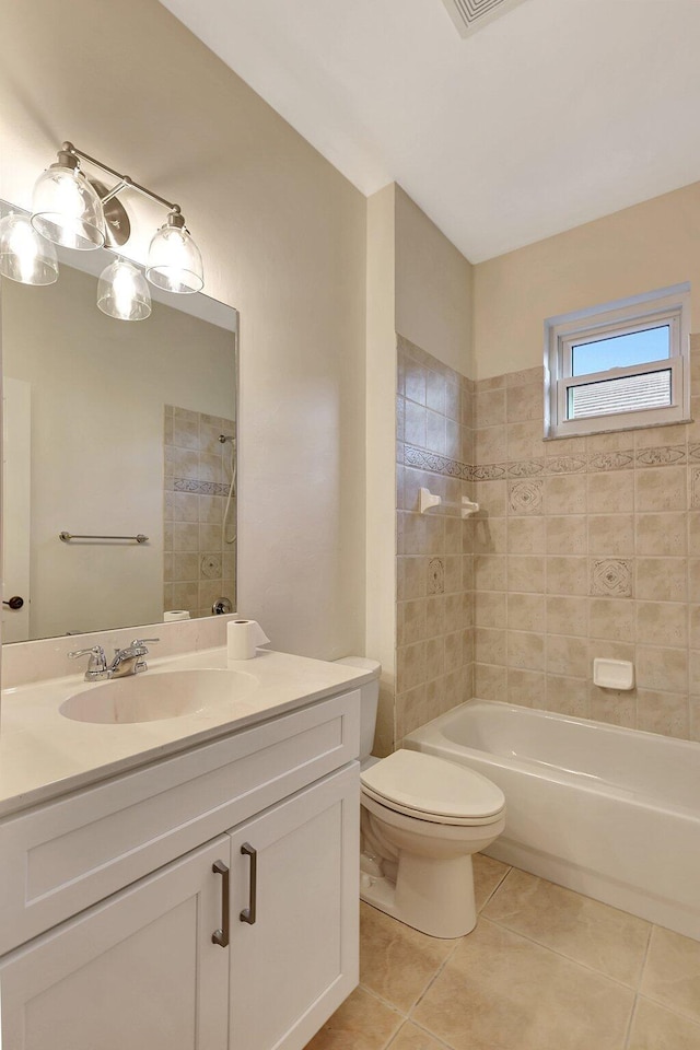 full bathroom with tile patterned flooring, vanity, tiled shower / bath combo, and toilet