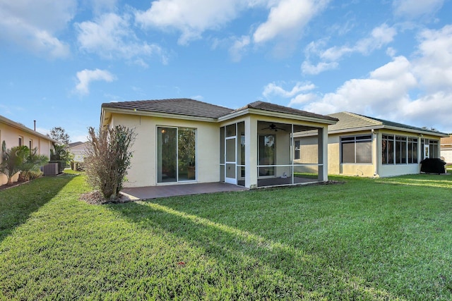 back of property with a lawn, a sunroom, and central AC unit