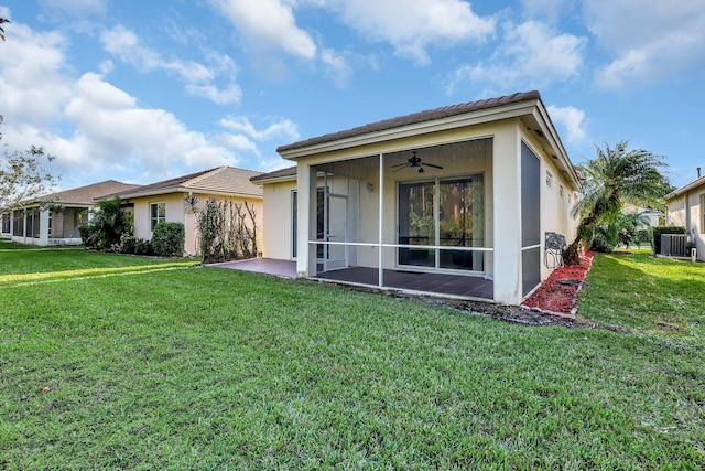 back of property with a lawn, ceiling fan, central AC unit, and a sunroom