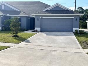 single story home with a front yard and a garage